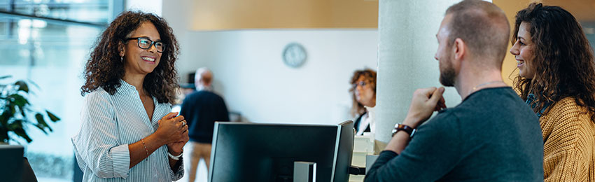 An administrative assistant works with colleagues in an office setting.