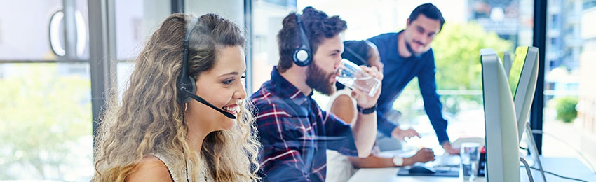Customer service staff answer phones in an office environment