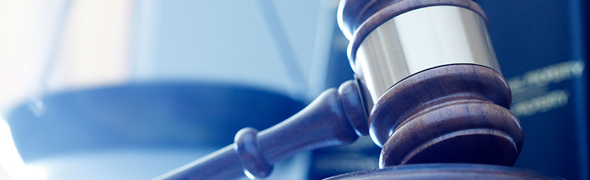 Photo of a gavel with scales of justice in the background