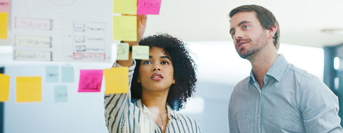 Two business professionals having a brainstorming session in a modern office space.