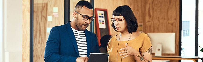 A social media manager discusses a strategy with a colleague