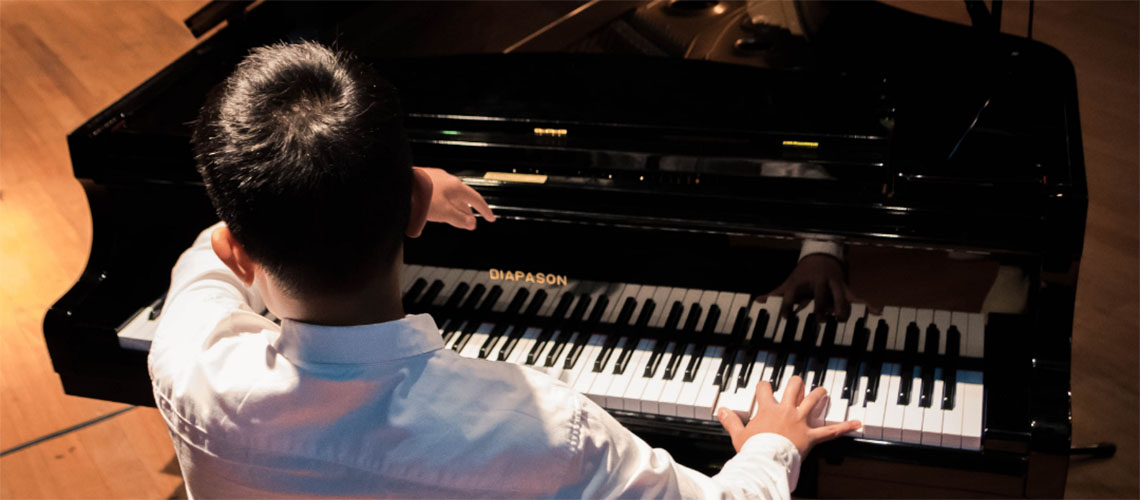  Student performing the piano on stage.