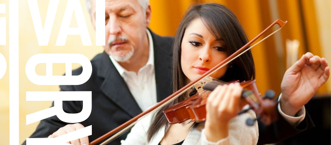 Woman learning the violin with an instructor correcting technique.