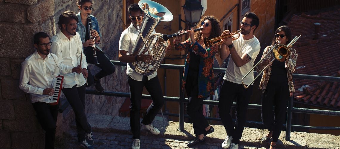 Group of seven musicians performing jazz on a rooftop terrace