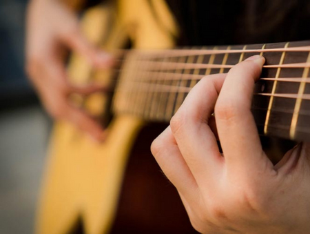 Close up of a a guitar being played.